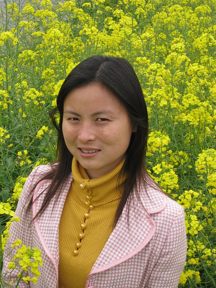 A photo of Sami in front of yellow flowers at a park in Shanghai