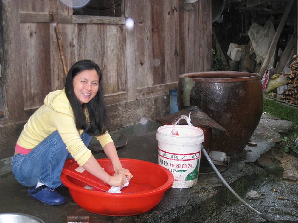 A photo of Sami washing clothes at her childhood home